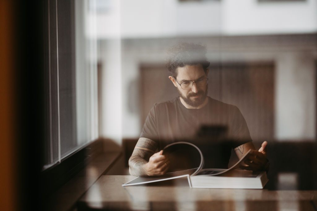 Baustellenkoordination: Bauleiter mit Plänen und Tablet auf dem Gelände“