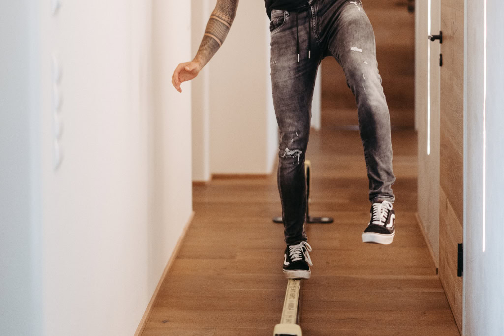 Ein Mann balanciert auf einer Slackline im Büro.