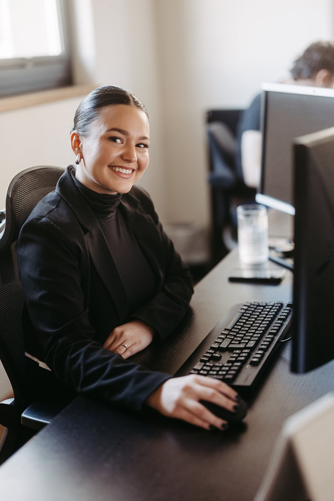 Eine Frau sitzt an einem Schreibtisch mit einem Computer.