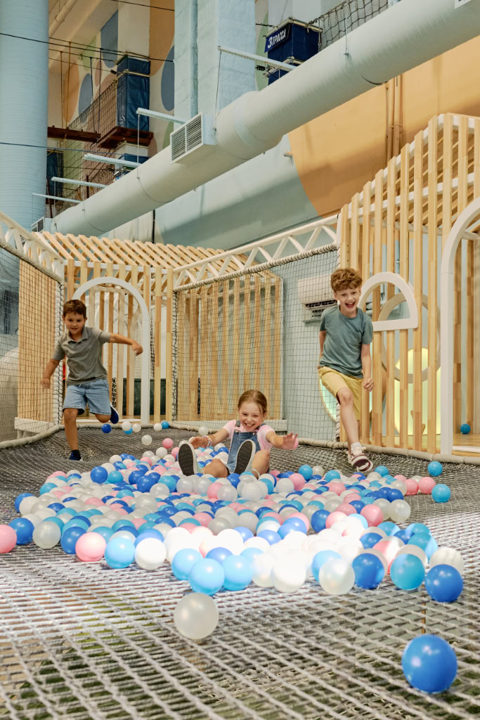 Kinder, die in einem Hotelbereich in einer Ballgrube spielen.